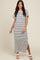 woman wearing a white and black striped maxi dress with short sleeves and a side slit