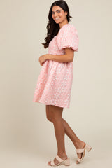 woman wearing a pink puff sleeve floral embroidered dress and beige heeled sandals