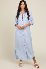 woman wearing a blue and white striped long button-up dress with rolled sleeves and a side slit