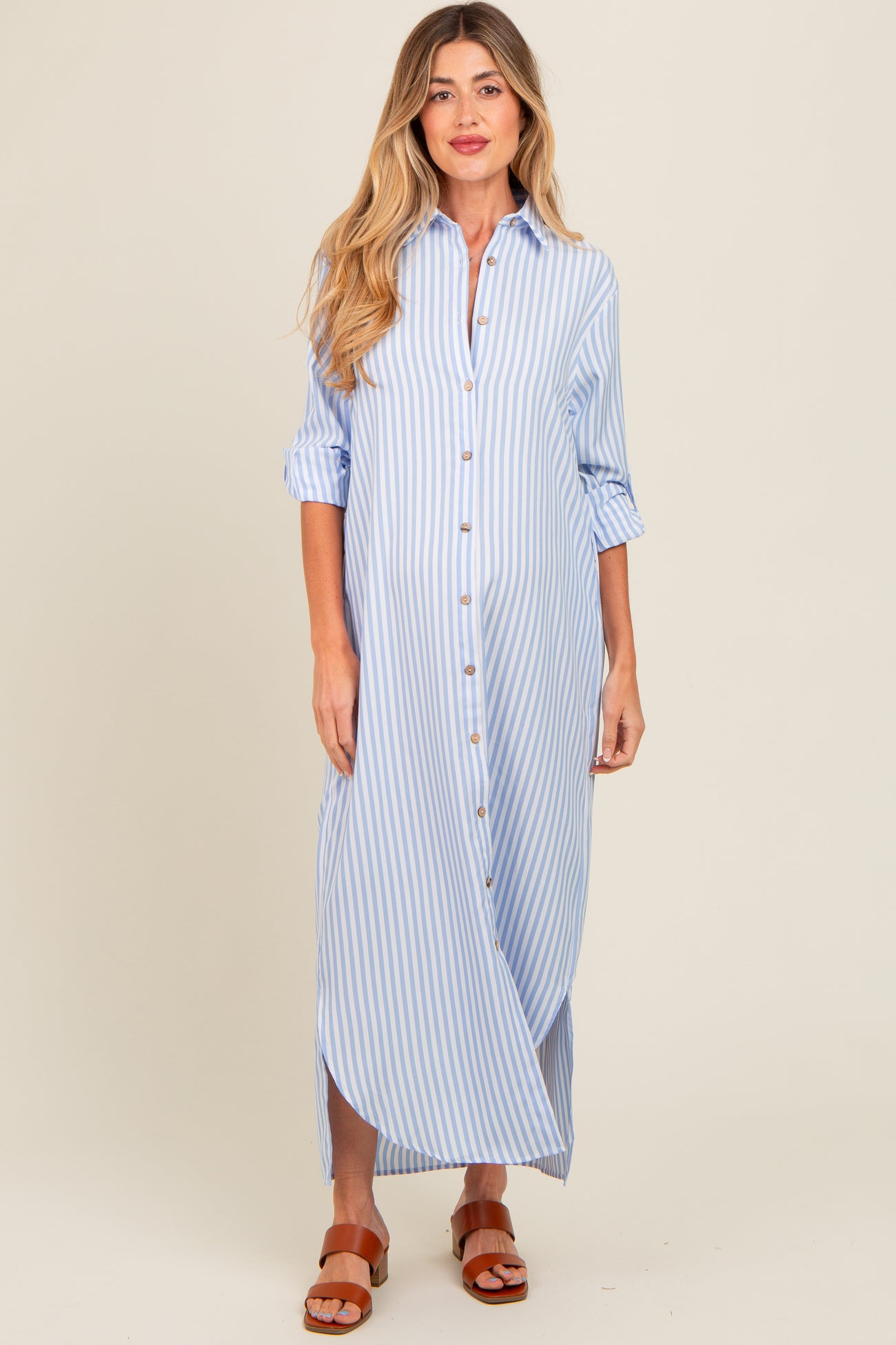 woman wearing a light blue and white striped maternity maxi dress with button front and rolled sleeves