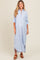 woman wearing a light blue and white striped maternity maxi dress with button front and rolled sleeves