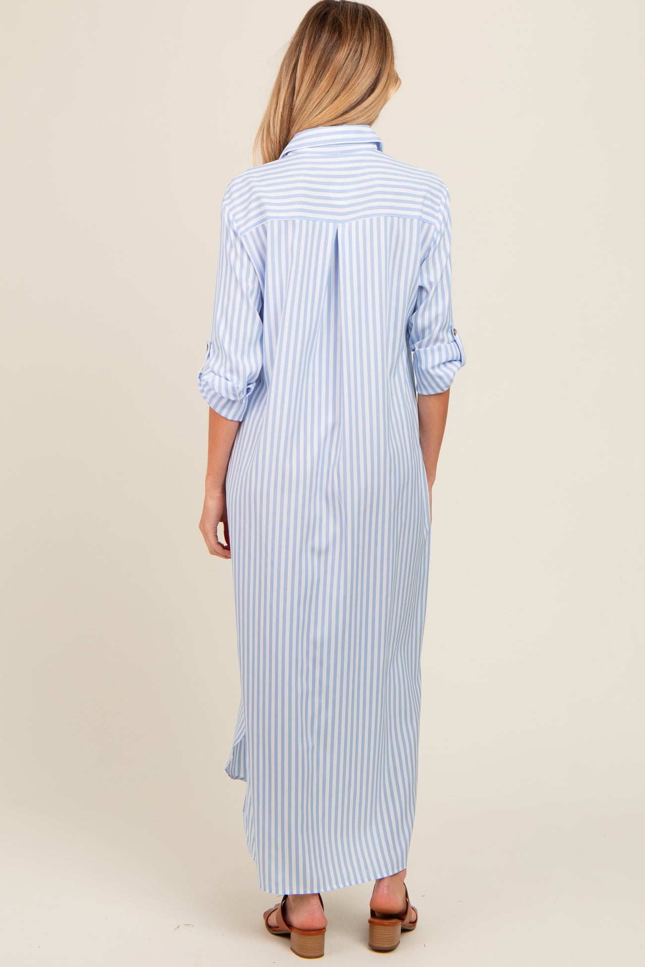woman wearing a blue and white striped maternity maxi dress, shown from the back with sleeves rolled up