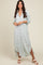woman wearing a light green and white striped maxi shirt dress with button detailing and side slits