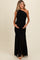 woman wearing a black one-shoulder maternity gown with ruching, holding her baby bump