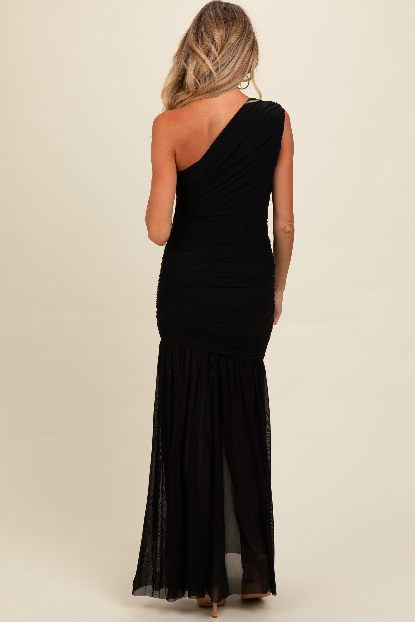 woman wearing a black one-shoulder ruched maternity gown with a flowy skirt and fitted bodice