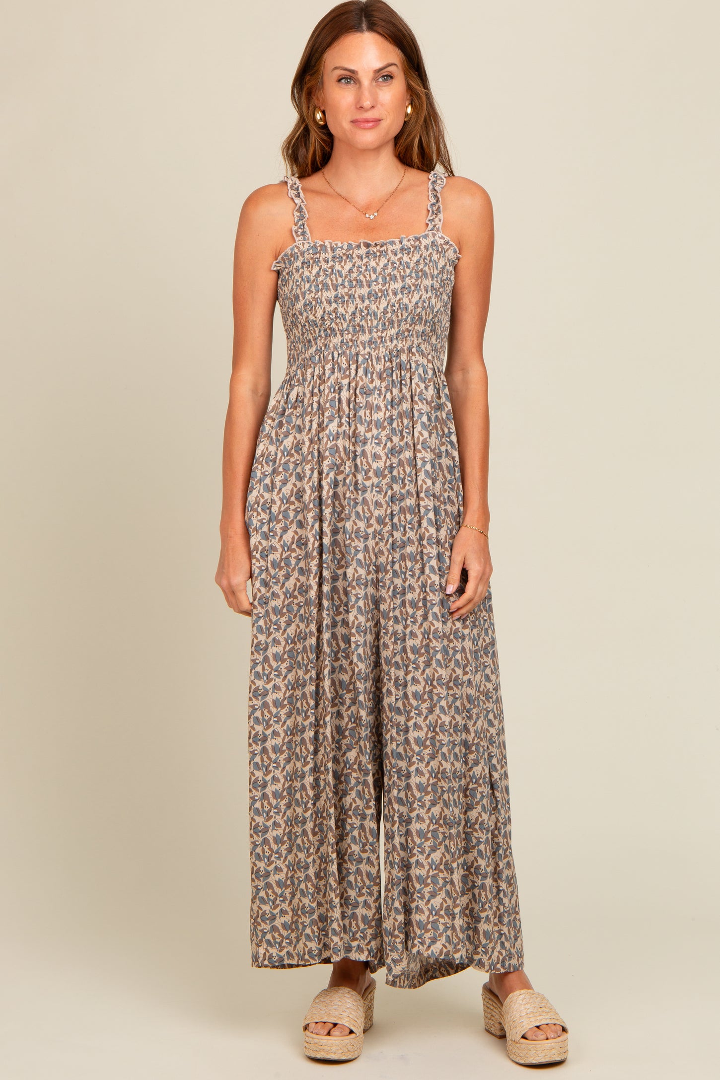 woman wearing a floral maxi dress with smocked bodice and braided straps