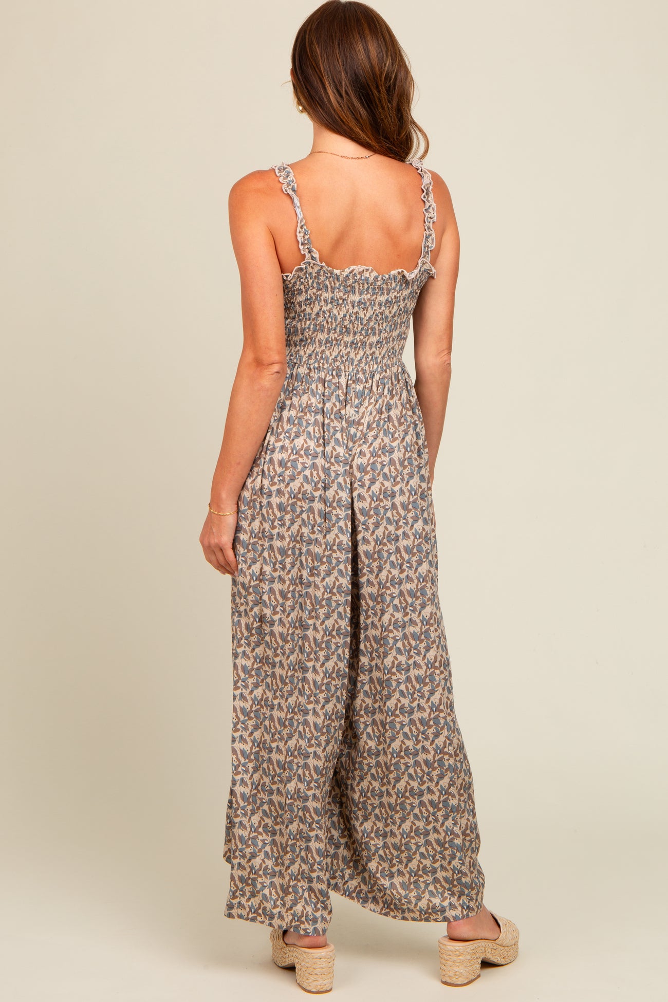 woman wearing a floral backless maxi dress with ruffled straps and a smocked bodice