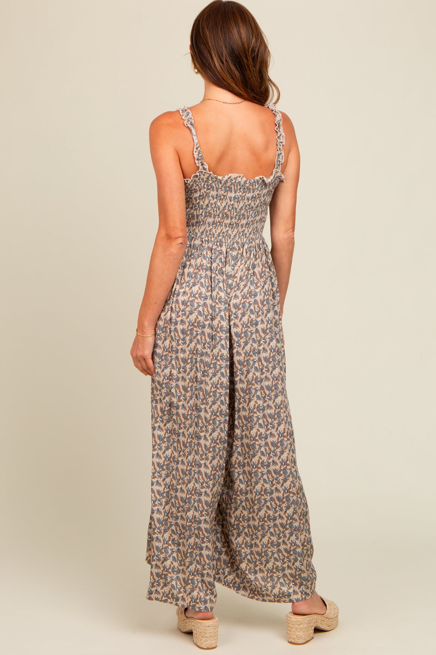 woman wearing a floral backless maxi dress with ruffled straps and a smocked bodice