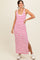 woman wearing a white and pink striped maxi dress with a side slit and casual sneakers