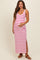 woman wearing a white and pink striped maternity maxi dress with side slits, highlighting her baby bump
