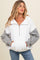 woman wearing a white and grey color block maternity sweatshirt with a half zipper and front pockets