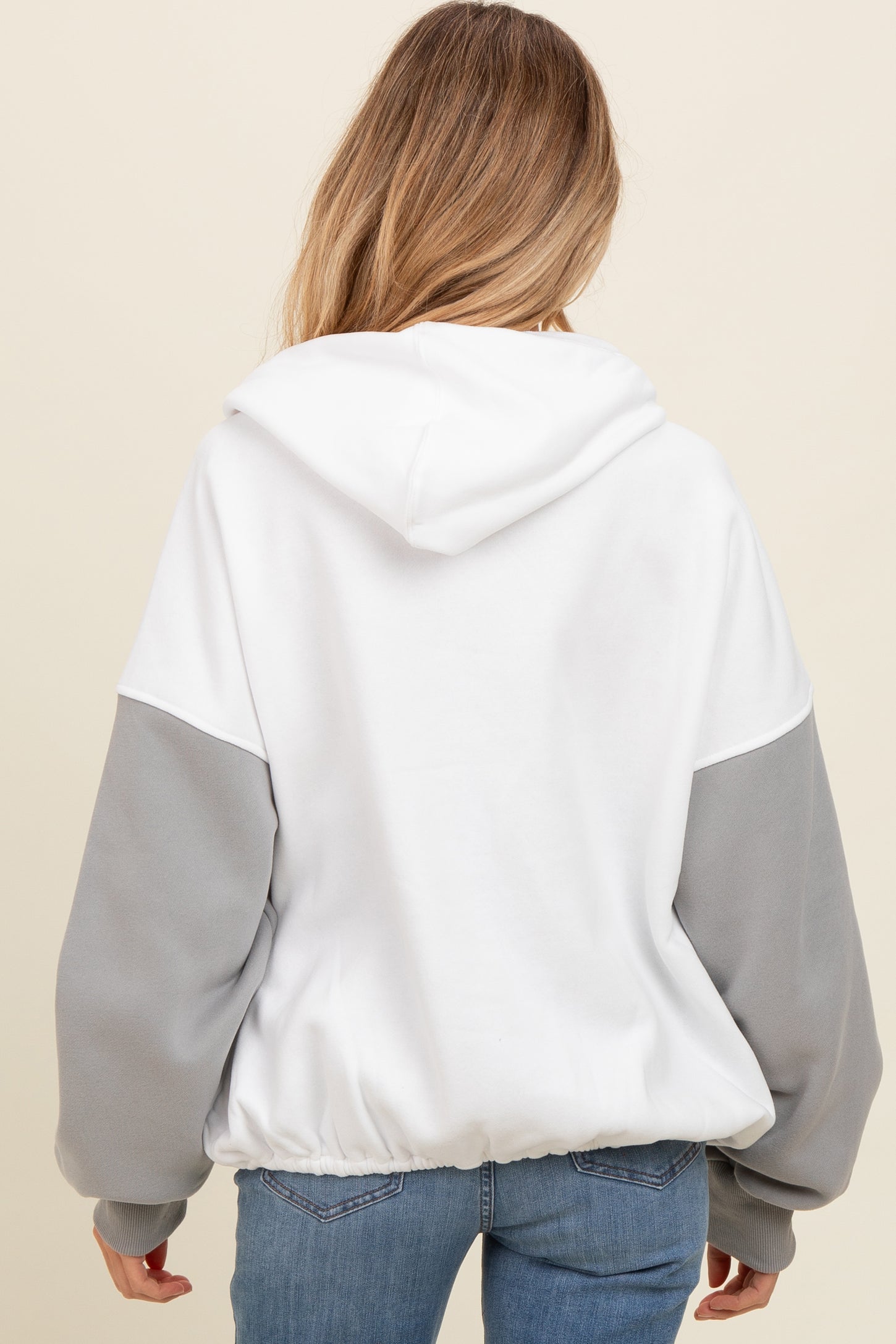 woman wearing a white and gray maternity hooded sweatshirt, showing the back view