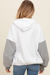 woman wearing a white and gray maternity hooded sweatshirt, showing the back view