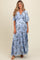 woman wearing a light blue floral maternity maxi dress with flutter sleeves and a visible baby bump