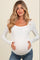 woman wearing a white long sleeve maternity top, highlighting her baby bump with a relaxed fit and scoop neckline