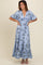 woman wearing a light blue floral maxi dress with wide sleeves and a ruffled hemline