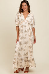 woman wearing a cream floral maxi dress with puff sleeves and a ruffled hem, standing on a neutral background