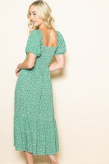 woman wearing a green floral midi dress with puff sleeves and a square back, shown from the back