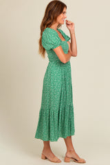woman wearing a green floral puff sleeve midi dress with a tiered skirt and a fitted bodice