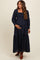 woman wearing a dark blue maternity maxi dress with smocked bodice and lace detailing, showing her baby bump
