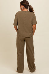 woman wearing a brown maternity loungewear set consisting of a short sleeve top and wide leg pants