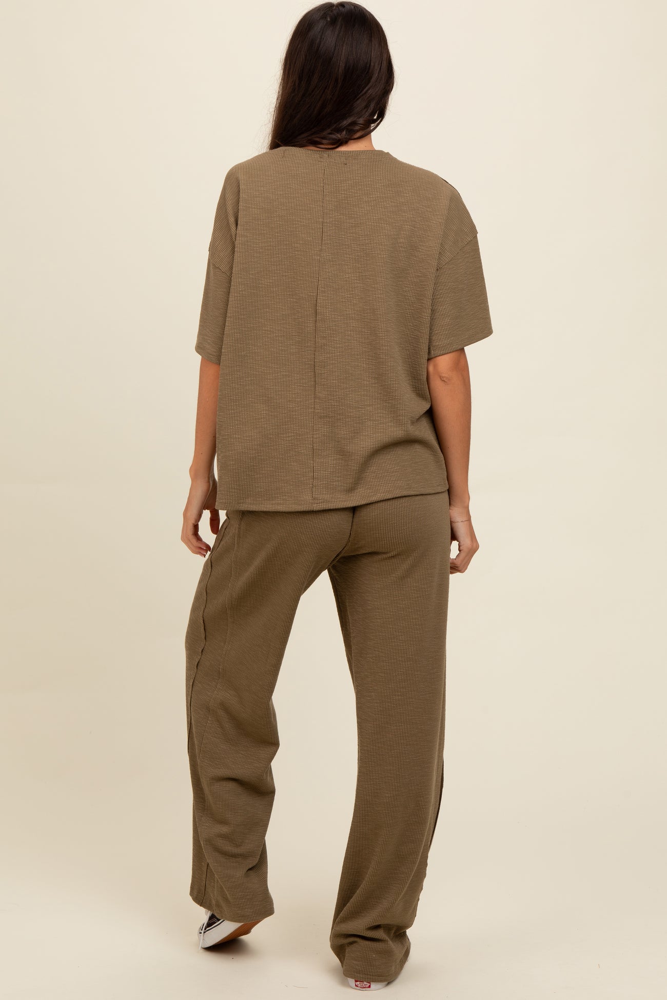 woman wearing an olive green two-piece lounge set with a loose fit top and wide-leg pants