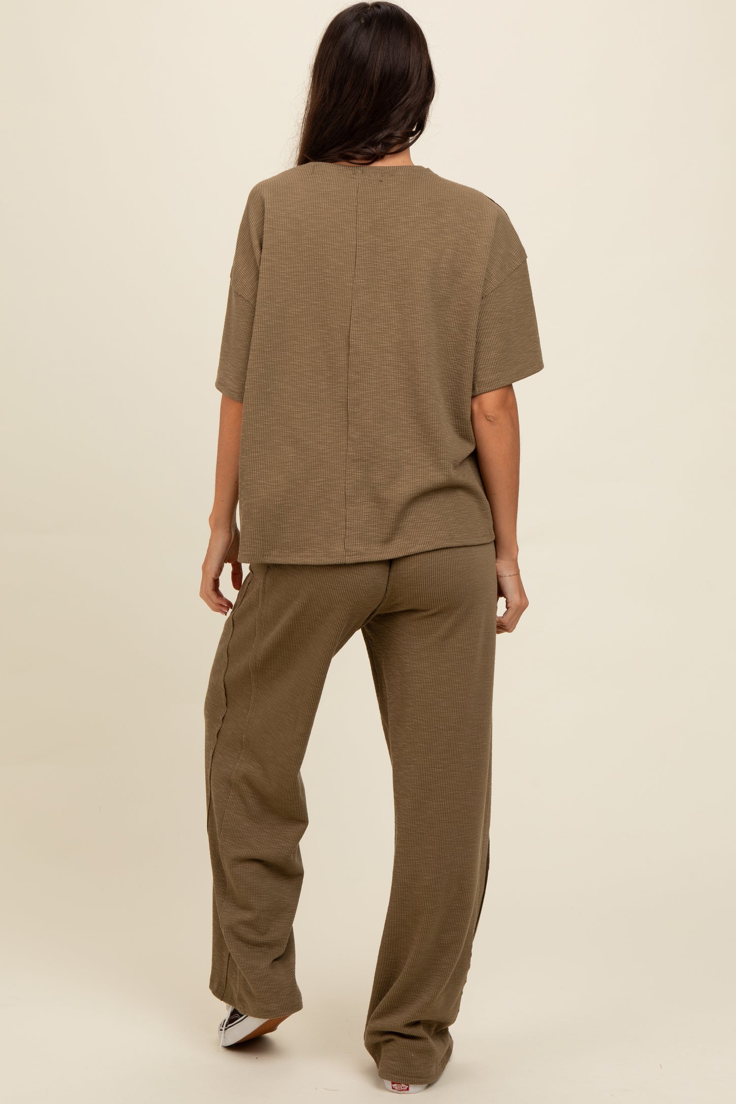 woman wearing an olive green two-piece lounge set with a loose fit top and wide-leg pants