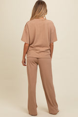 woman wearing a light brown ribbed maternity loungewear set consisting of a relaxed fit top and wide leg pants