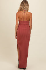 woman wearing a rust colored ribbed maternity maxi dress with a back slit and adjustable straps