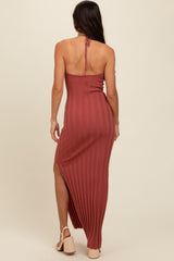 woman wearing a rust ribbed maxi dress with a high slit and tying detail at the back
