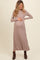 woman wearing a taupe long sleeve maternity dress and holding her baby bump