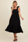 woman wearing a black midi dress with ruffle straps and a tiered skirt