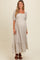 woman wearing a cream floral maternity maxi dress with puff sleeves and a tiered hem, showing her baby bump