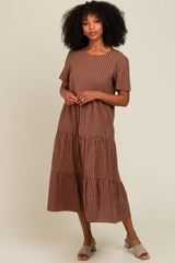 woman wearing a brown checkered tiered midi dress with short sleeves and a relaxed fit