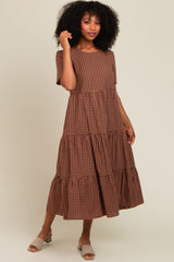 woman wearing a brown gingham tiered midi dress with short sleeves and a relaxed fit