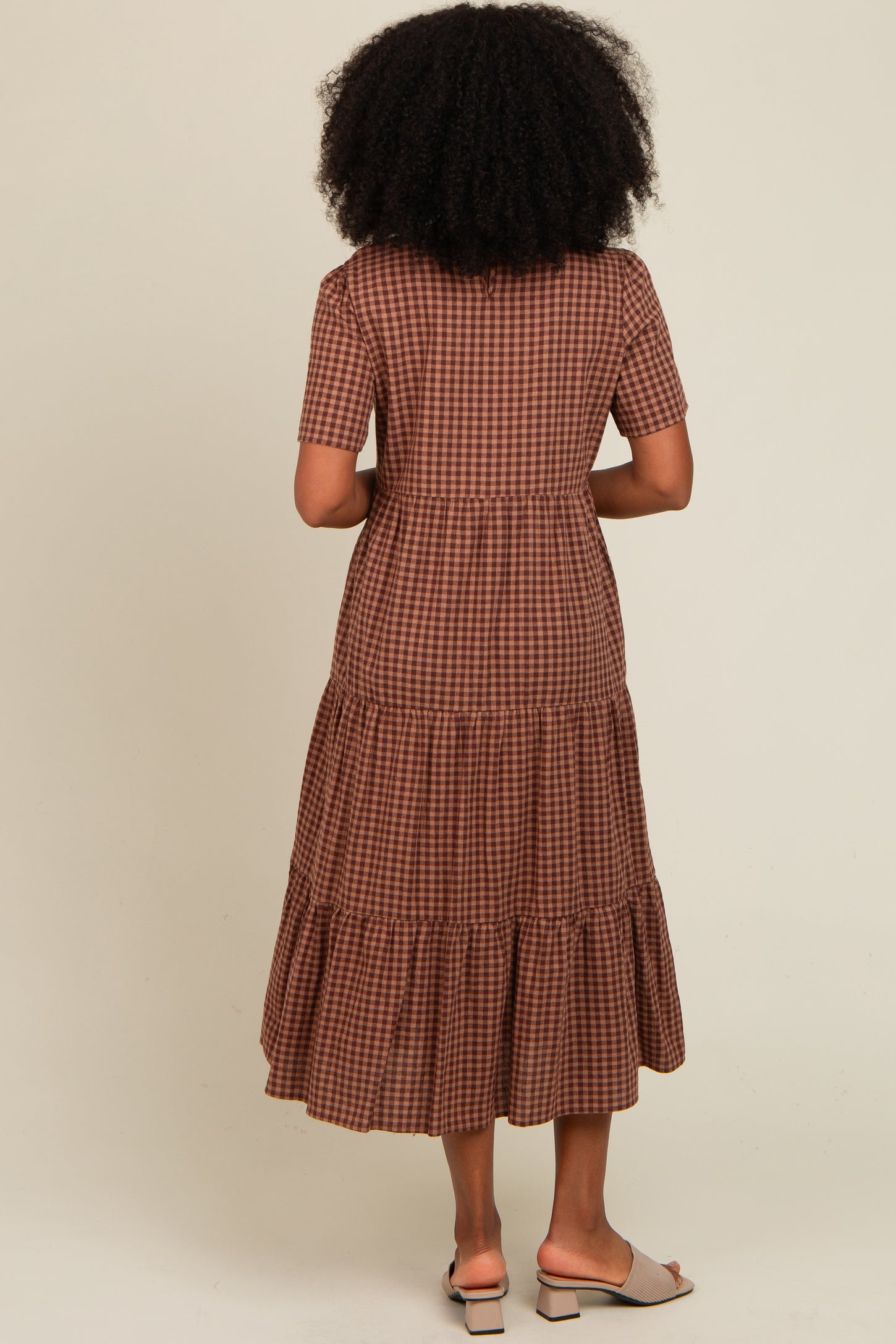 woman wearing a brown checkered tiered maxi dress with short sleeves
