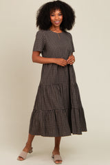 woman wearing a brown checkered tiered maxi dress with short sleeves and posing casually