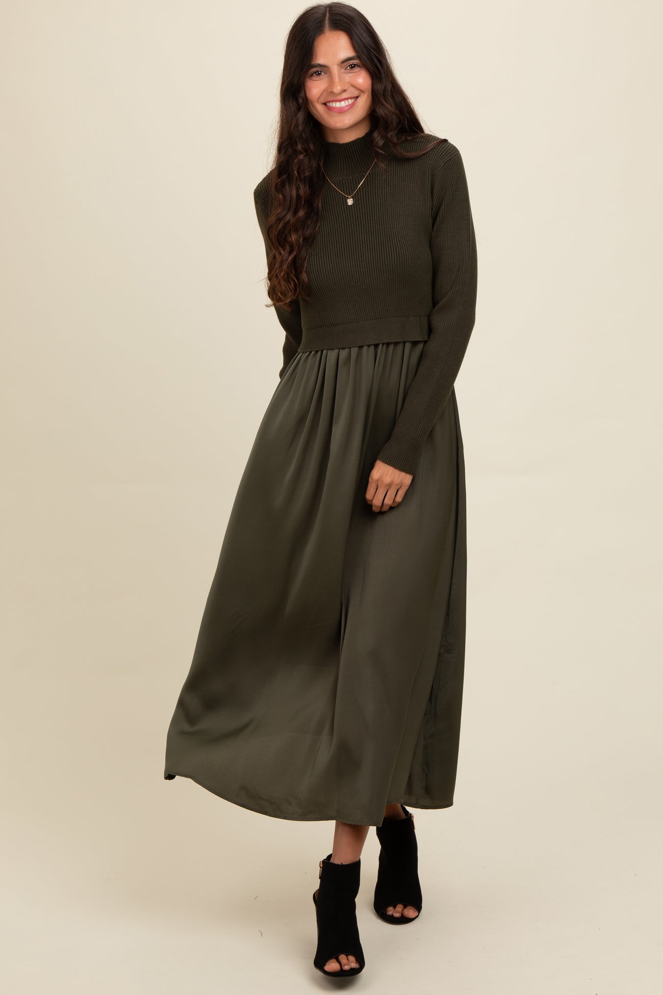 woman wearing a dark olive green long sleeve cropped sweater with a matching maxi skirt and black heeled ankle boots