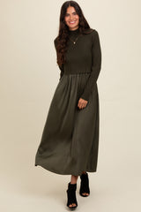 woman wearing a dark olive green long sleeve cropped sweater with a matching maxi skirt and black heeled ankle boots