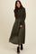 woman wearing a dark olive green long sleeve cropped sweater with a matching maxi skirt and black heeled ankle boots