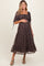 woman wearing a dark floral maternity dress with a square neckline and puff sleeves, holding her baby bump
