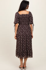 woman wearing a dark floral midi dress with puff sleeves and tie details, shown from the back