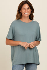 woman wearing a soft green short sleeve top with a relaxed fit and rolled sleeves