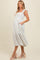 woman wearing a white floral maternity dress with ruffled sleeves and pockets, showcasing her baby bump