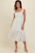 woman wearing a white floral midi dress with ruffled sleeves and a square neckline