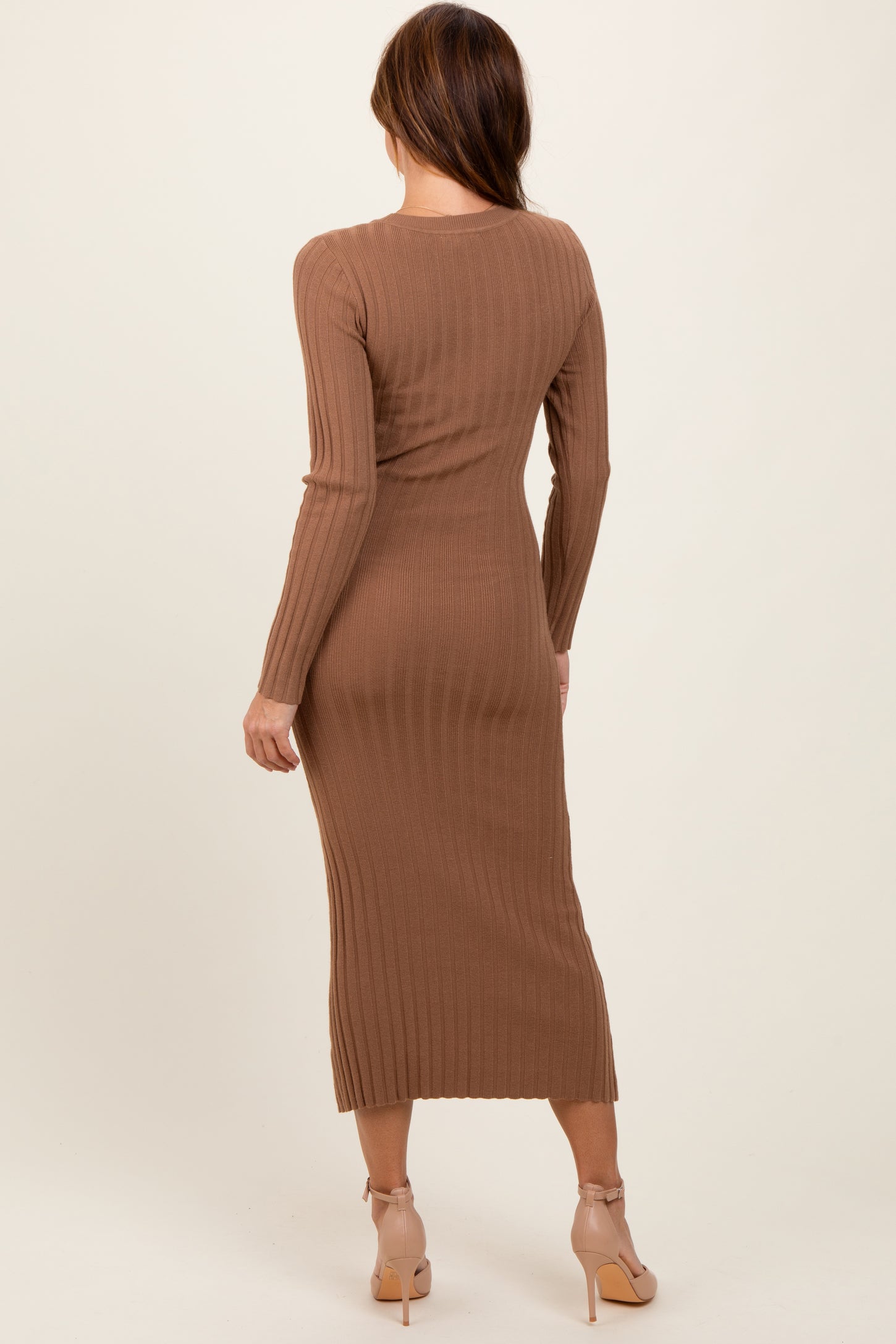 woman wearing a fitted ribbed brown midi dress with long sleeves, seen from the back