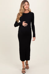 woman wearing a black long sleeve ribbed maternity dress and holding her baby bump