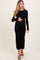 woman wearing a black long sleeve ribbed maternity dress and holding her baby bump