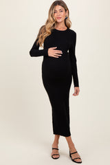 woman wearing a black ribbed long sleeve maternity dress and holding her baby bump