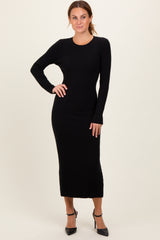 woman wearing a black ribbed long sleeve midi dress with a fitted silhouette and styled with black high heels